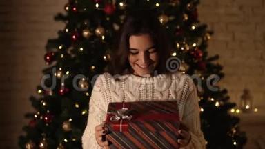 女孩许个愿，打开圣诞礼包.. 节日和新年的概念。 女孩很开心